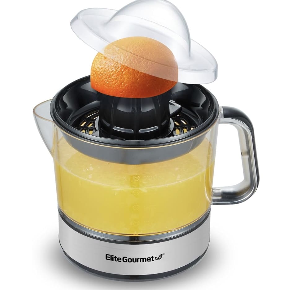 A citrus juicer with a clear container is in use, squeezing an orange half under a transparent dome lid while you dream of that healthy lemon loaf recipe. The container brims with fresh orange juice. The brand logo "Elite Gourmet" is visible on the base.